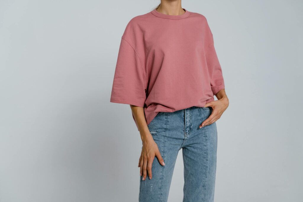 Model wearing a pink t-shirt and jeans, perfect for casual wear mockups.